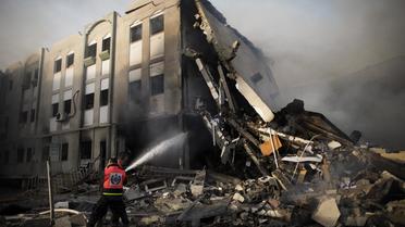 Des pompiers palestiniens éteignent un incendie après des frappes israéliennes sur le bâtiment du ministère de l'Intérieur du Hamas, le 16 novembre 2012 à Gaza [Marco Longari / AFP]