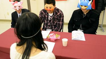 Trois hommes discutent avec une femme lors d'un "speed dating" masqué au Japon, le 23 novembre 2012 à Washinomiya [Toshifumi Kitamura / AFP]