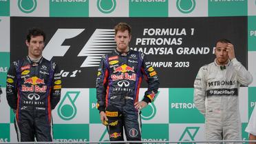 Les pilotes de Red Bull Mark Webber (g) et Sebastien Vettel (c) et de Mercedes Lewis Hamilton,  sur le podium du GP de de Malaisie de F1, le 24 mars 2013 à Sepang. [Philippe Lopez / AFP]
