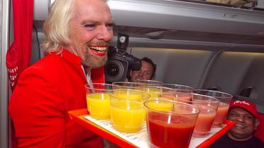 Le milliardaire britannique Richard Branson, le 12 mai 2013, en hôtesse de l'air, à bord d'un vol de la compagnie AirAsia [Tony Ashby / AFP]