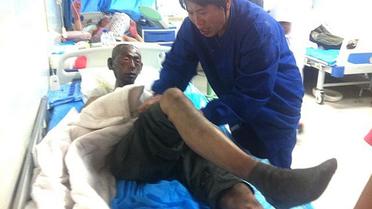Un homme blessé dans l'incendie d'un abattoir de volailles est pris en charge, le 3 juin 2013 dans un hôpital de Dehui [ / AFP]