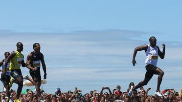 Le sprinteur jamaïcain Usain Bolt (D) effectue une course de 150 m le 31 mars 2013 sur la plage de Copacabana, au Brésil [Ari Versiani / AFP]