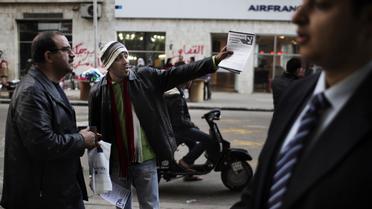 Un opposant distribue des tracts appelant à voter contre la Constitution, le 13 décembre 2012 au Caire [Marco Longari / AFP]