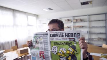 Charb, le directeur de Charlie Hebdo, tient un exemplaire du journal dans ses mains, le 19 septembre 2012 à Paris [Fred Dufour / AFP]