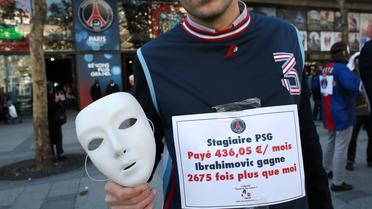 Un membre du groupe "Sauvons les riches" devant la boutique officielle du Paris Saint-Germain, sur les Champs-Elysées à Paris, le 31 octobre 2012 [Thomas Samson / AFP]