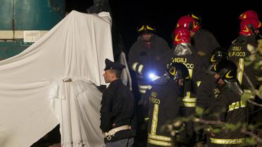 Des pompiers sur les lieux de la collision entre un train et une voiture qui transportait des travailleurs roumains en Calabre, le 24 novembre 2012 [Mario Tosti / AFP]