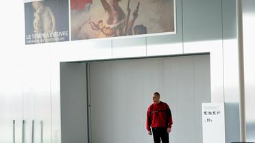 Un garde en faction devant l'entrée fermée de la Galerie du temps au Louvre-Lens où est exposée "La liberté guidant le peuple" de Delacroix qui a été vandalisée, le 8 février 2013 [Philippe Huguen / AFP]