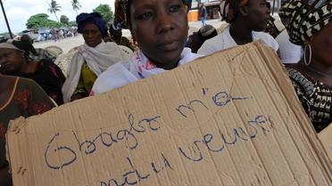 Une victime des violences post-électorales de 2010 en Côte d'Ivoire manifeste le 28 février 2013 à Abidjan, à l'occasion d'une audience de Laurent Gbagbo à La Haye [Sia Kambou / AFP]