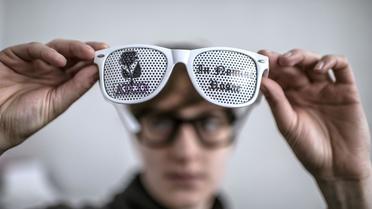 Un employé de Lulu Frenchie examine une paire de lunettes aux verres décorés d'une pellicule imprimé, le 28 février 2013 à Lyon [Jeff Pachoud / AFP]