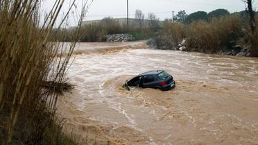 La voiture d'une automobiliste emportée par la crue du Réart, un petit cours d'eau près de Perpignan, le 6 mars 2013 [Raymond Roig / AFP]