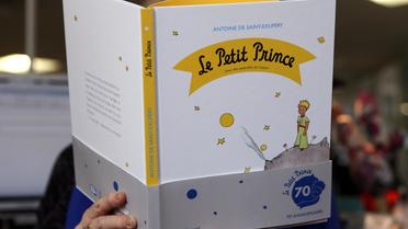 Une femme lit une édition du Petit Prince de Saint-Exupéry, le 11 avril à Paris [Patrick Kovarik / AFP]