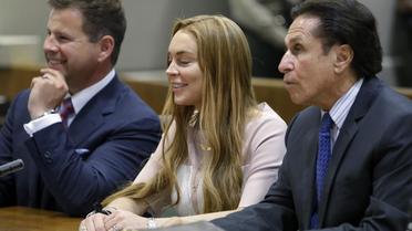 La starlette hollywoodienne Lindsay Lohan entre ses avocats, lors d'une audience au tribunal le 18 mars 2013 à Los Angeles [Reed Saxon / Pool/AFP]