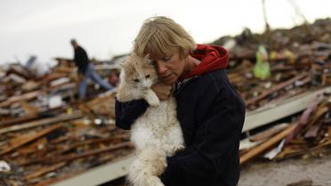 Une femme et son chat le 21 mai 2013 au milieu des décombres à  à Moore, une banlieue d'Oklahoma City dévastée par une tornade [Joshua Lott / AFP]