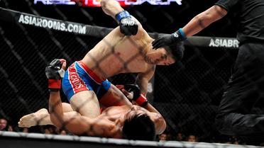 Le Japonais Koji Oishi frappe son adversaire philippin Honorio Benario pendant un combat de mixed martial arts (MMA), le 31 mai 2013 à Manille.
