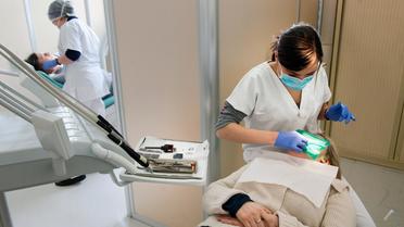 Une étudiante en chirurgie dentaire soigne un patient le 23 février 2012 au service dentaire des Hospices civils de Lyon [Philippe Merle / AFP/Archives]