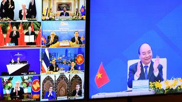 Le Premier ministre vietnamien Nguyen Xuan Phuc (à droite sur l'écran) se félicite de l'accord signé par 15 pays, le 15 novembre 2020, à HanoÏ [Nhac NGUYEN / AFP]