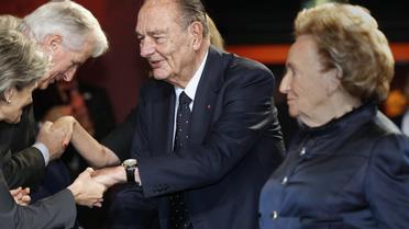 L'ancien président Jacques Chirac et son épouse Bernadette saluent des invités à leur arrivée à la cérémonie de remise du Prix de la Fondation Chirac, au musée du Quai Branly à Paris, le 21 novembre 2013 [Jacky Naegelen / Pool/AFP/Archives]