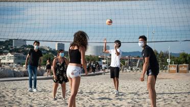 Partie de volleyball avec des masques sur la plage du Prado à Marseille, le 1er juin 2020 [CLEMENT MAHOUDEAU / AFP]