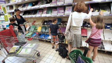 Une mère et sa fille achètent des fournitures scolaires dans un supermarché [Frederick Florin / AFP/Archives]