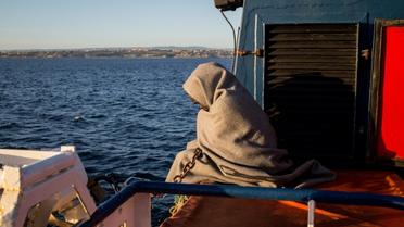 Un migrant enveloppé dans une couverture sur le pont du Sea-Watch peu avant l'arrivée du navire à Catane (Sicile), le 31 janvier 2019 [FEDERICO SCOPPA / AFP]