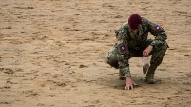 Un soldat américain recueille du sable à Omaha Beach, en Normandie, le 5 juin 2019 [JOEL SAGET / AFP]