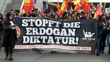 Des manifestants brandissent une bannière réclamant "la fin de la dictature de Erdogan" lors d'un rassemblement à Cologne, le 5 novembre 2016 [PATRIK STOLLARZ / AFP]