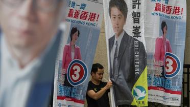 Un homme installe les banderoles de campagne à Hong Kong, le 4 septembre 2016 [Anthony WALLACE / AFP]