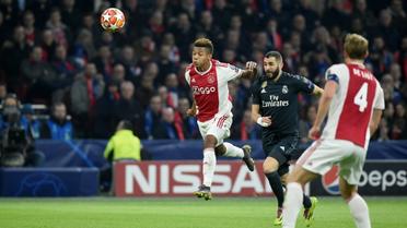 Le Français du Real Madrid Karim Benzema (c) entre deux joueurs de l'Ajax dont David Neres (g), en 8e de finale aller de la C1, le 13 février 2019 à Amsterdam  [JOHN THYS          / AFP]