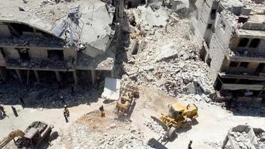Les secouristes s'activent au pied d'un immeuble détruit par un bombardement, à Maaret al-Noomane, dans le nord-ouest de la Syrie, le 22 juillet 2019 [Omar HAJ KADOUR / AFP]