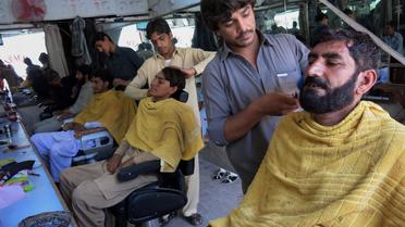 Un Pakistanais se fait raser la barbe, dans la ville de Bannu près du Waziristan du nord, le 6 juillet 2014 [Karim Ullah / AFP]