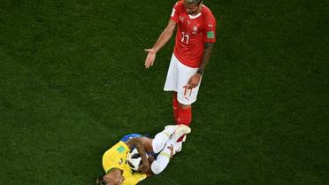 Le Brésilien Neymar au sol sous les yeux du Suisse Valon Behrami, agacé, lors du Mondial, le 17 juin 2018 à Rostov [Jewel SAMAD / AFP]