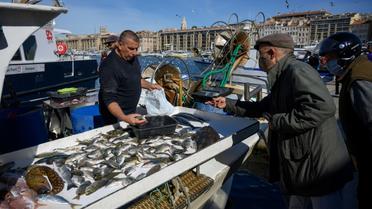 Un client portant un masque de protection achète du poisson à Marseille, le 3 mai 2020 [Christophe SIMON / AFP]