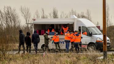 Des membres de l'association Vie Active, mandatée par l'Etat, distribuent des repas aux migrants, le 9 mars 2018 à Calais [PHILIPPE HUGUEN / AFP]