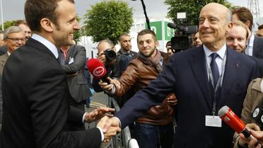 Emmanuel Macron et Alain Juppé le 16 juin 2016 à  Villepinte [PATRICK KOVARIK / AFP/Archives]