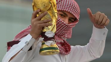 Un jeune qatarien tient une réplique de la Coupe du monde de football, le 3 décembre 2010 à Doha [Marwan Naamani / AFP/Archives]
