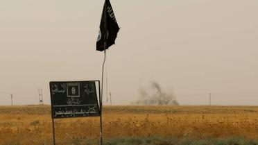 Drapeau et panneau de l'organisation État islamique (EI) le 11 septembre 2015 à Daquq en Irak [MARWAN IBRAHIM / AFP/Archives]