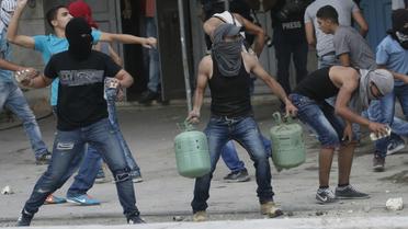 De jeunes palestiniens lancent des pierres contre les forces de sécurité israéliennes au checkpoint de Qalandia entre Jérusalem et Ramallah, le 6 octobre 2015 [ABBAS MOMANI / AFP]