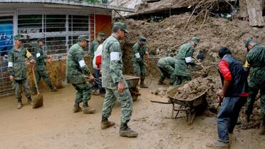 Des soldats mexicains aident à déblayer des maisons endommagées par les glissements de terrains provoquées par les pluies de la tempête Earl, dans la région de Xalapa dans l'Etat de Veracruz au Mexique, le 06 août 2016 [EDUARDO MURILLO / AFP]