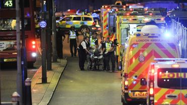 Des officiers de police et des membres des secours prennent en charge un blessé à London Bridge, au centre de Londres, le 3 juin 2017 [DANIEL SORABJI                       / AFP]
