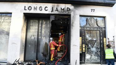 Les pompiers interviennent sur un feu à la boutique Longchamp, pendant la manifestation des "gilets jaunes", sur les Champs-Elysées  à Paris, le 16 mars 2019 [Alain JOCARD / AFP]