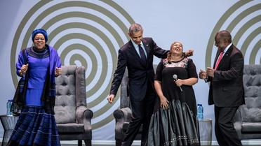 L'ex président américain Barack Obama, la veuve de Nelson Mandela, Graça Machel (à gauche) et le président sud-africain Cyril Ramaphosa (à droite) dansent en compagnie de la chanteuse Thandiswa Mazwai lors d'une cérémonie en l'honneur de Mandela, le 17 juillet 2018 à Johannesbourg [MARCO LONGARI / AFP]