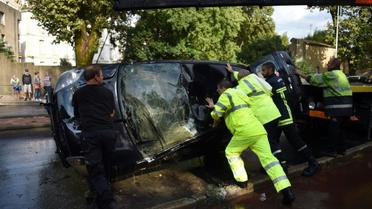 Des secours aident à renverser une Ford Fiesta dans laquelle deux personnes sont mortes le 23 août 2015 [Pascal Guyot / AFP]