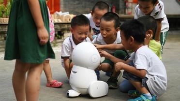 Des enfants de l'école maternelle Yiswind en Chine autour du robot Keeko, le 30 juillet 2018 [GREG BAKER / AFP]