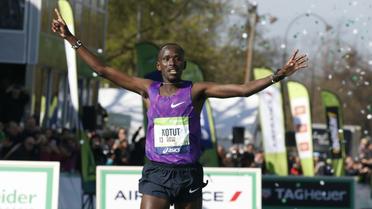 Le Kenyan Cybrian Kotut franchit la ligne d'arrivée du 40e marathon de Paris, le 3 avril 2016 [THOMAS SAMSON / AFP]