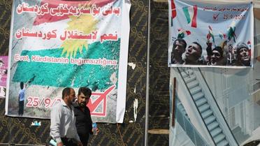 Des Irakiens passent devant une affiche pour le référendum d'indépendance du Kurdistan, le 24 septembre 2017 à Kirkouk  [AHMAD AL-RUBAYE / AFP]