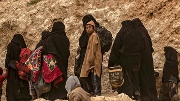 Des membres présumés du groupe Etat islamique (EI) fuient le village de Baghouz (Syrie), le 14 mars 2019 [Delil souleiman / AFP]