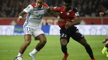 L'attaquant néerlandais de Lyon Memphis Depay (g) à la lutte avec le défenseur ivoirien de Lille Yves Dabila le 1er décembre 2018 à Villeneuve-d'Ascq [FRANCOIS LO PRESTI / AFP]