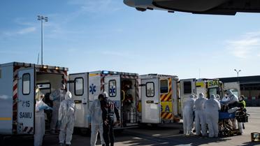 Du personnel soignant transporte des malades gravement atteints par le Covid-19 dans des avions, stationnés sur le tarmac de l'aéroport de Orly le 4 avril 2020 [BERTRAND GUAY / AFP]