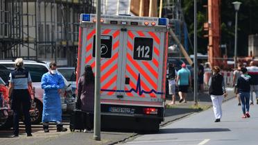 Une ambulance est garée devant les résidences des employés de la société d'abattoir Toennies, pendant leur mise en quarantaine dans le quartier Suerenheide de Verl, le 22 juin 2020. 