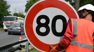 Un employé de la Direction interdépartementale des routes (DIR) installe un panneau de limitation de vitesse à 80 km/h sur une route nationale, le 28 juin 2018 à Grenade [PASCAL PAVANI / AFP/Archives]